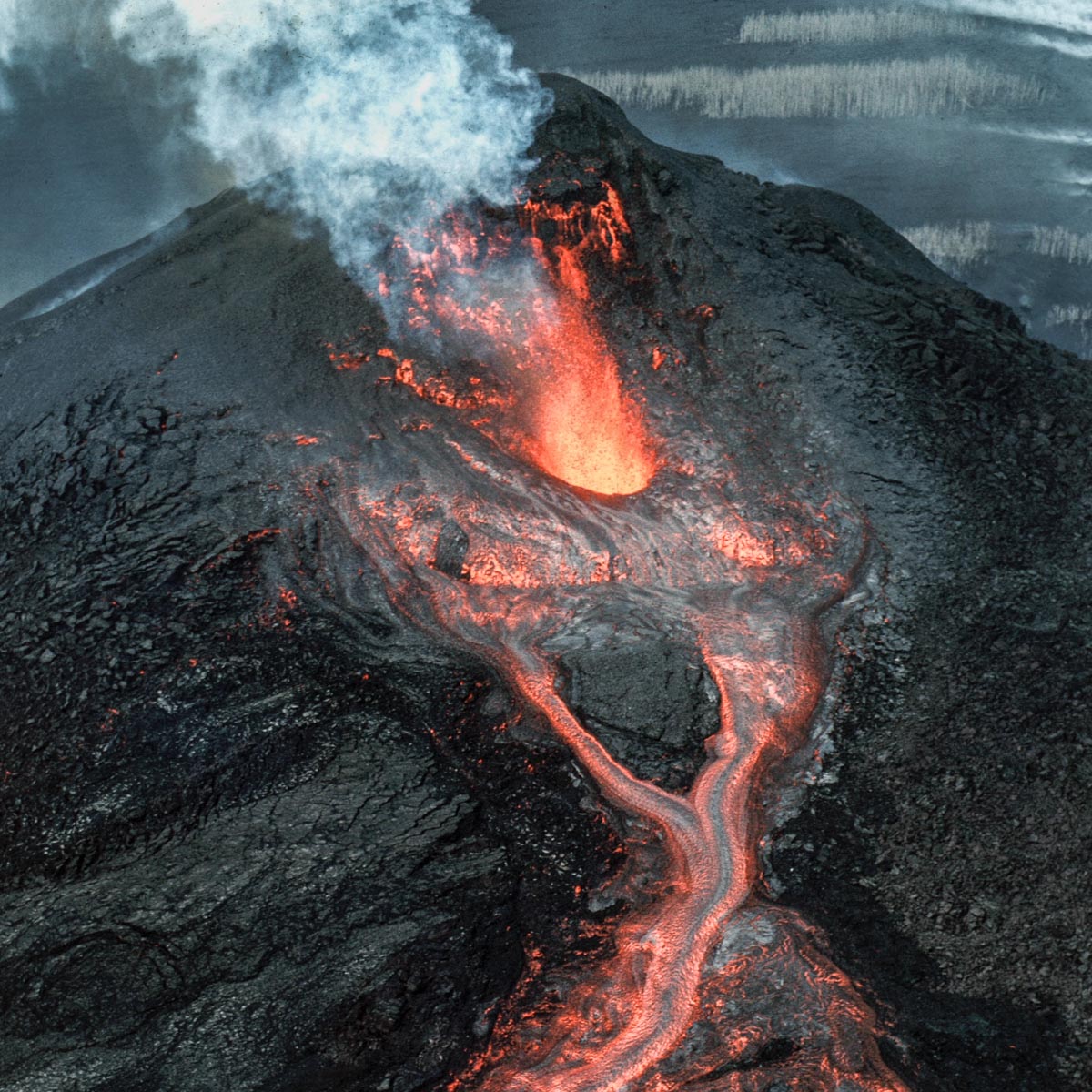 Suomalainen tulivuori. Musta kivilaji joka on syntynyt tulivuoren purkauskanavista.